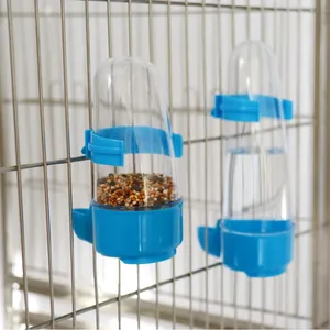 Automatischer transparenter Vogeltränke und Futterspender an den Metallstäben des Käfigs