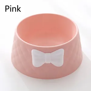 Close-up of a deep pink pet bowl featuring a white bowknot and elegant diamond pattern texture