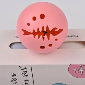 Balle rose en silicone pour chat avec découpe en arête de poisson et clochette.