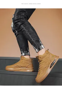 Dettaglio di sneaker alte da uomo color cammello indossate con jeans strappati