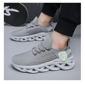 Detailed view of grey breathable fly-knit sneakers featuring a unique wave-pattern sole.
