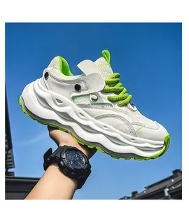Close-up of white chunky dad shoe with lime green details and thick sole against blue sky