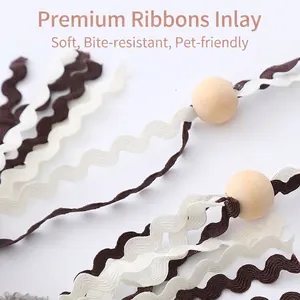 Detail of cat teaser wand toy featuring wavy fabric ribbons and natural wooden beads