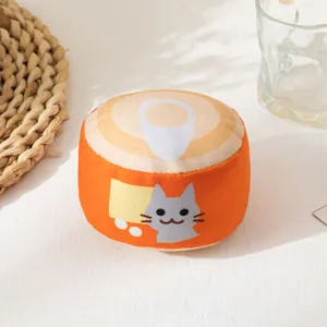 Primer plano de un suave juguete de peluche para gatos naranja con forma de lata y cascabel