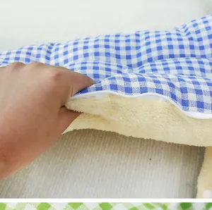 Detail of thick fleece lining and blue checkered fabric of warm pet sleeping bag