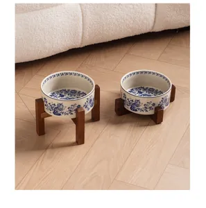 Detail shot of two blue and white ceramic cat bowls on elegant acacia wood stands