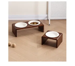 Détail de supports d'alimentation en bois d'acacia avec bols en céramique sur parquet