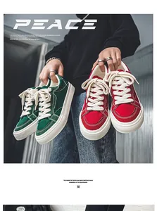 Close-up van stijlvolle groene en rode canvas lage sneakers met de hand vastgehouden retro.