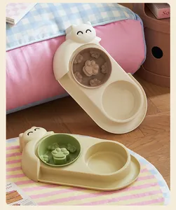 Elevated double cat bowl set featuring a slow feeder paw design in a cozy pet setting