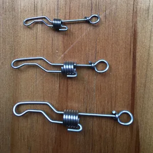 Close-up of three sizes of stainless steel bird leg ring connector clips on wood