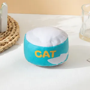 Primer plano de juguete de peluche para gato con forma de lata azul y hierba gatera.