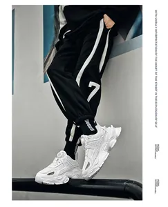 Close-up of men's white breathable mesh sports sneakers featuring a modern rotary buckle closure