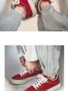 Detailweergave van rode low-top canvas sneakers met witte veters en retrostijl