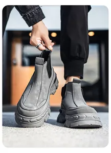Dettaglio di stivali da lavoro grigi alti slip-on con robuste suole spesse in gomma