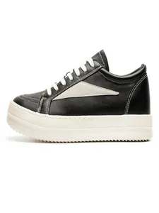 Vue latérale de baskets compensées en cuir noir avec flèche blanche et semelle épaisse.