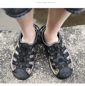 Bovenaanzicht van zwarte ademende leren outdoorsandalen voor heren op een steen
