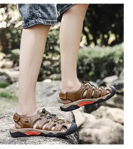 Gedetailleerde weergave van bruine leren outdoorsandalen op rotsachtig terrein