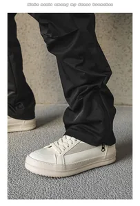 Vue détaillée des baskets de ville blanches en cuir pour hommes avec pantalon noir