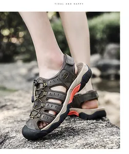 Gedetailleerde close-up van bruine leren outdoorsandalen voor heren op rotsachtig terrein