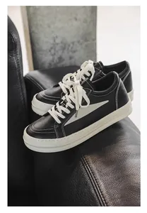 Gros plan de baskets de luxe en cuir noir avec des détails en chevron blanc élégants.