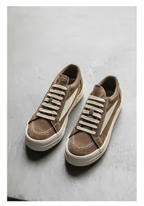 Vue détaillée des baskets en daim marron de style high-street avec de gros lacets blancs