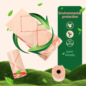 Detailweergave van roze biologisch afbreekbare hondenpoepzakjes met bottenprint op gras.