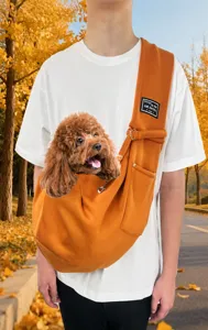 Durable orange pet shoulder carrier bag for small dogs and cats shown in outdoor use