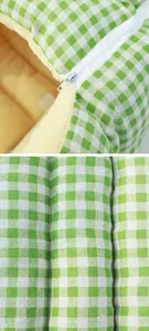 Close-up of the durable zipper and soft green gingham fabric on a pet bed