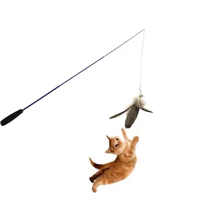 Action shot of an orange cat jumping to catch a retractable feather wand toy