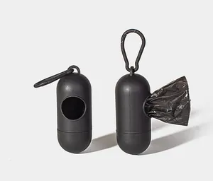 Close-up of black capsule-shaped portable dog waste bag dispensers with hooks