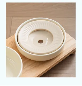 Détail du bol d'eau en céramique pour animaux avec disque flottant sur support en bois de chêne.