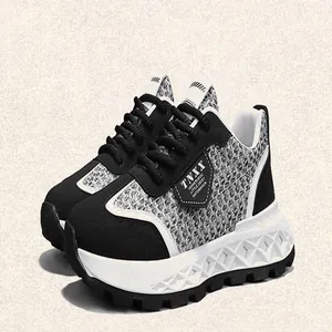 Detail of casual retro sneakers featuring a black and white woven pattern and thick platform