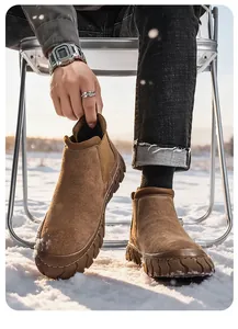 Gros plan de bottines de travail en daim marron pour hommes dans la neige