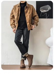 Bottines Chelsea marron pour hommes portées avec un jean foncé et une veste de travail kaki