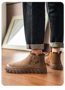 Détail de bottines de travail en daim marron avec semelles épaisses antidérapantes.