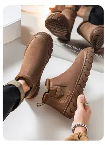 Détail de bottes de travail en daim marron avec semelles en caoutchouc et design sans lacets.