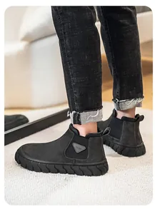 Gros plan latéral de bottines Chelsea pour hommes en daim noir avec semelle épaisse