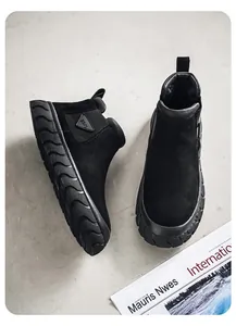 Gros plan sur des bottines de travail en daim noir avec semelles épaisses en caoutchouc.