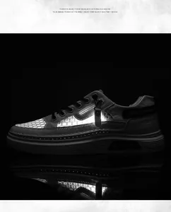 Close-up detail of grey mesh cut-out sneaker with side zipper and reflective sole