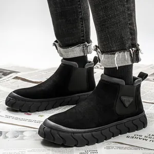 Bottines Martin montantes en daim noir pour hommes avec semelle épaisse texturée sur journal