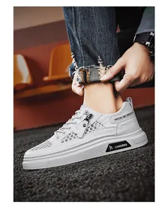 Close-up of white breathable mesh board shoes for men with zipper and text detail.