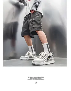 Gros plan de baskets compensées grises pour hommes avec une décoration unique de breloque astronaute.