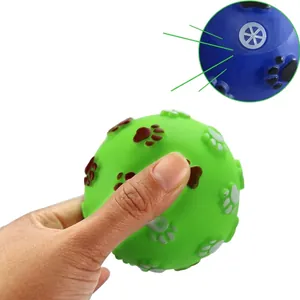 Close-up detail of squeaky pet toy ball with paw prints showing the internal squeaker