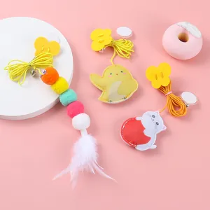 Detail view of hanging cat toys featuring felt chick, cat and colorful ball designs