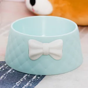 Detailed view of a macaron blue pet bowl with white bowknot and diamond texture.