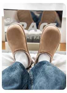 Vista dettagliata di accoglienti zoccoli in camoscio beige con fodera in peluche e jeans