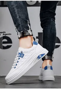 Detailed view of stylish white men's sneakers with blue accents and quilted texture.