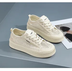 Detail van elegante crème platform sneakers van kant met het 'FASHION' logo label