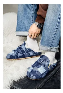 Dettaglio di sabot in denim patchwork da uomo con fodera in pile bianco e fibbia.