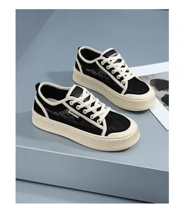 Gedetailleerd zijaanzicht van ademende zwarte kanten sneakers voor dames met dikke crèmekleurige